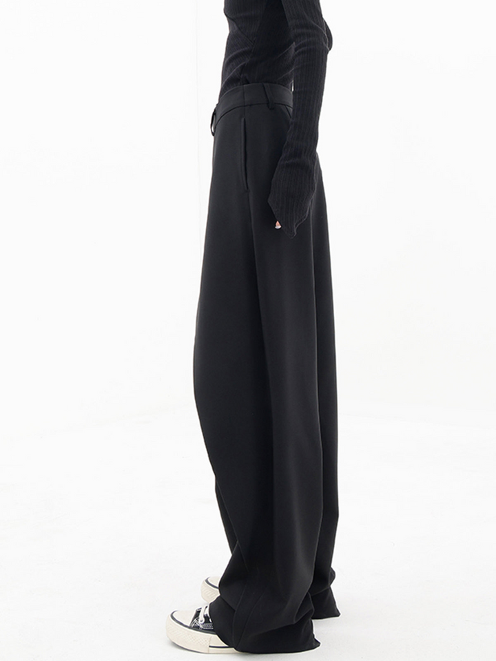 Textured detail of chic women's baggy trousers; modern design with relaxed fit and unique asymmetric waist.