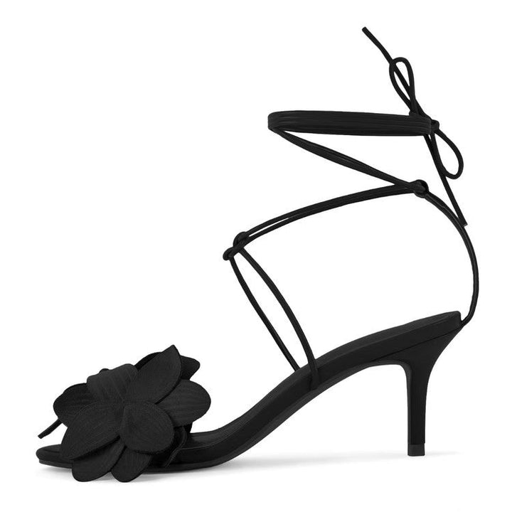 Close-up of Beatrice women's strappy kitten heel sandals. Floral appliqué, open toe, and chic ankle-tie design.