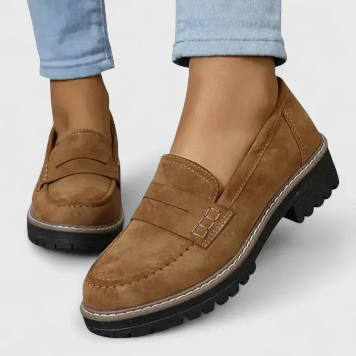 Fashionable black women's chunky lug-sole penny loafers. Platform slip-ons perfect for versatile everyday footwear.