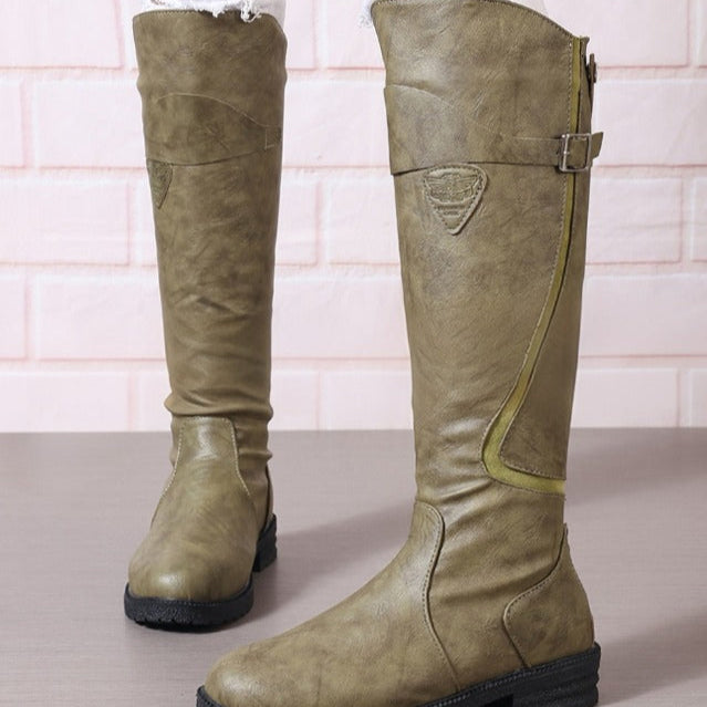 Elegant women's equestrian winter boots with a prominent gold buckle, block heel, and durable lug sole.