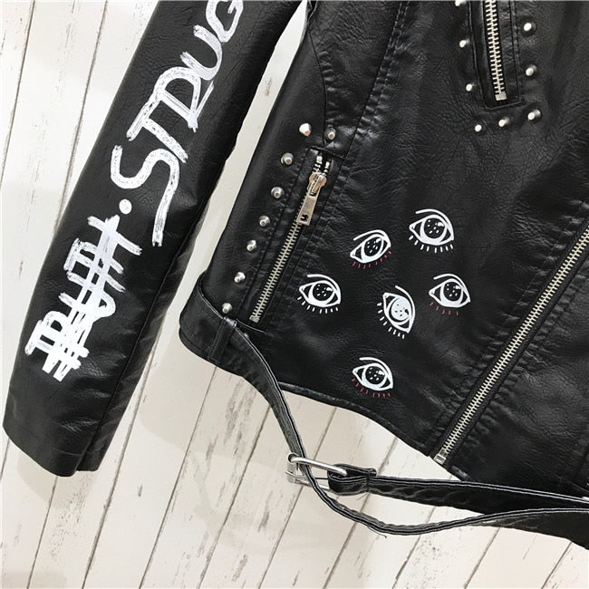 Close-up of a women's black jacket showcasing intricate silver rivet details. Fashionable and bold outerwear.
