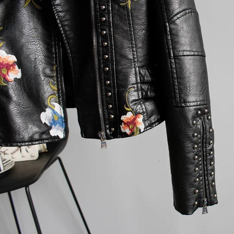 Sleek women's studded moto jacket with intricate floral details, ideal for a bold and fashionable statement.