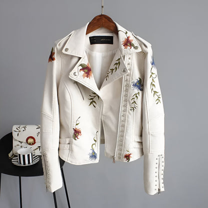 Front view of a women's edgy studded biker jacket with an asymmetrical zipper and subtle floral accents.
