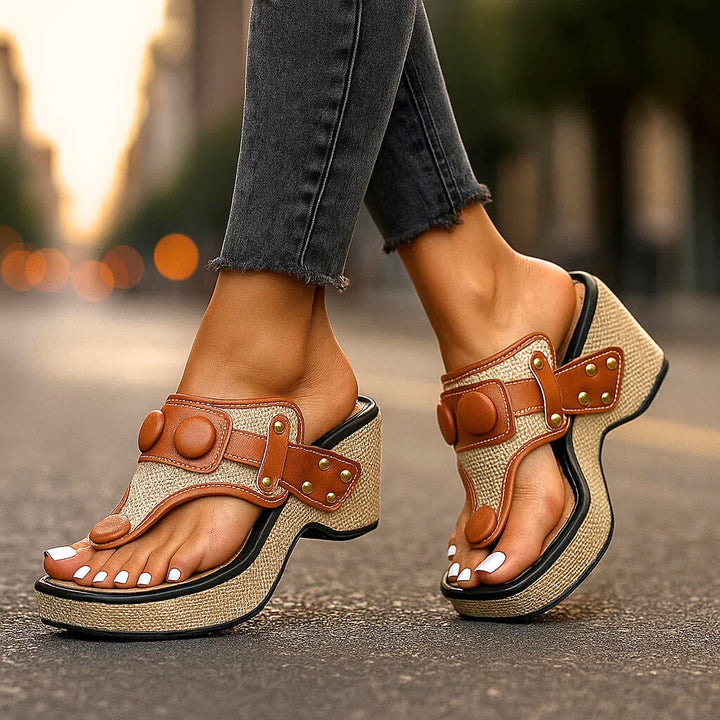 Close-up of women's white wedge platform thong sandals, showcasing comfortable footbed and arch support.