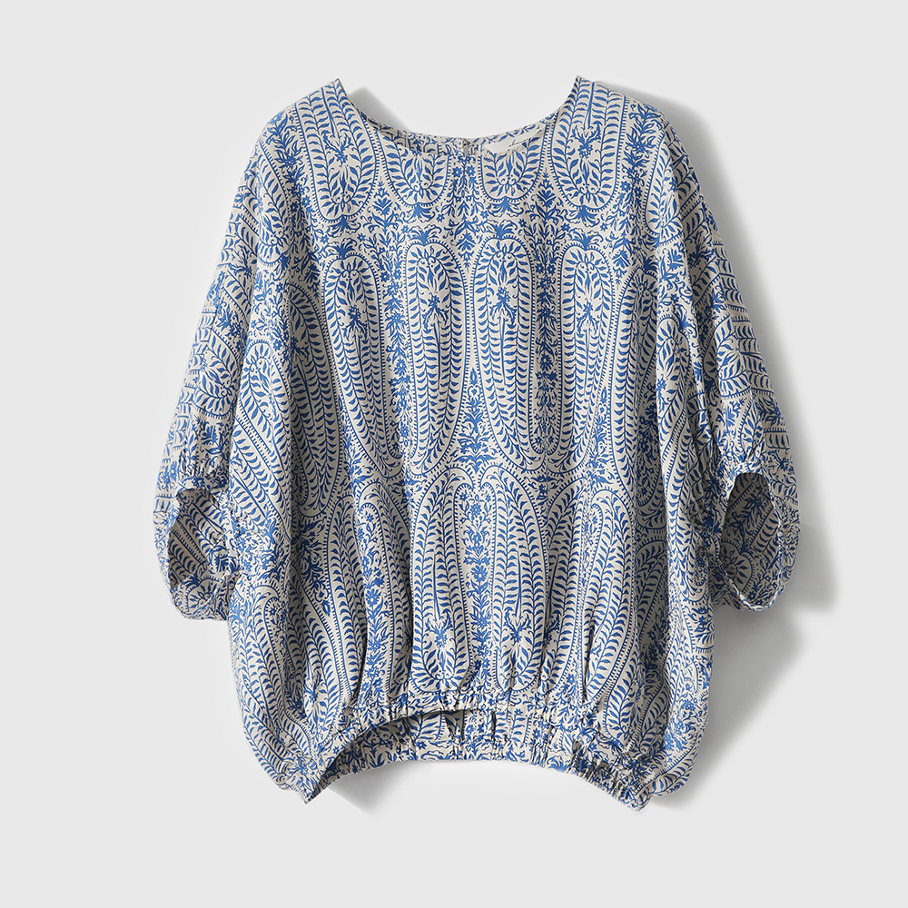 Close-up of a women's bohemian floral print top, featuring elegant balloon sleeves & relaxed fit. Casual spring/summer.