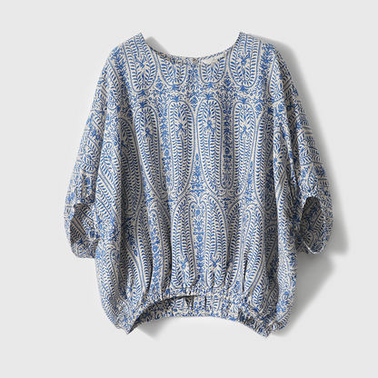 Close-up of a women's bohemian floral print top, featuring elegant balloon sleeves & relaxed fit. Casual spring/summer.