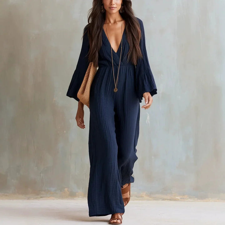 Bohemian style wide leg jumpsuit for women, featuring a deep V-neck and elegant flare sleeves, ideal vacation outfit.