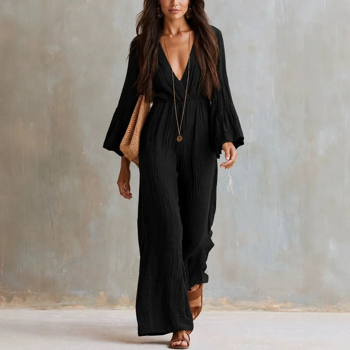 Chic women's wide leg jumpsuit with a deep V-neck and stylish flare sleeves, embodying a relaxed bohemian style.