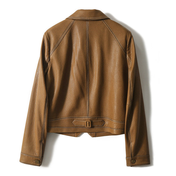 Brown women's cropped moto jacket. Close-up of textured faux leather on a fashionable biker jacket.