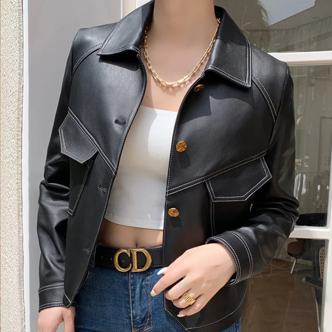 Full view of black women's cropped moto jacket. Edgy biker style outerwear, a fashionable statement piece.