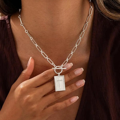 Elegant silver paperclip chain necklace for women, adorned with a bold cross pendant. Fashion jewelry gift.