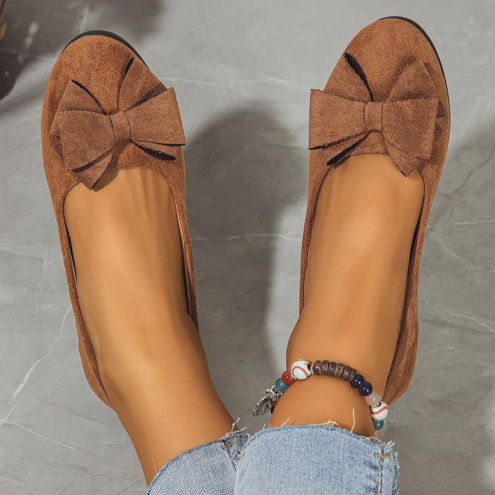 Feminine black wedge ballet flats, round toe, bow detail, easy to slip on.