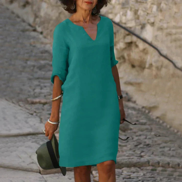 Woman wearing a breezy V-neck midi dress, enjoying a comfortable summer day. Casual elegance.