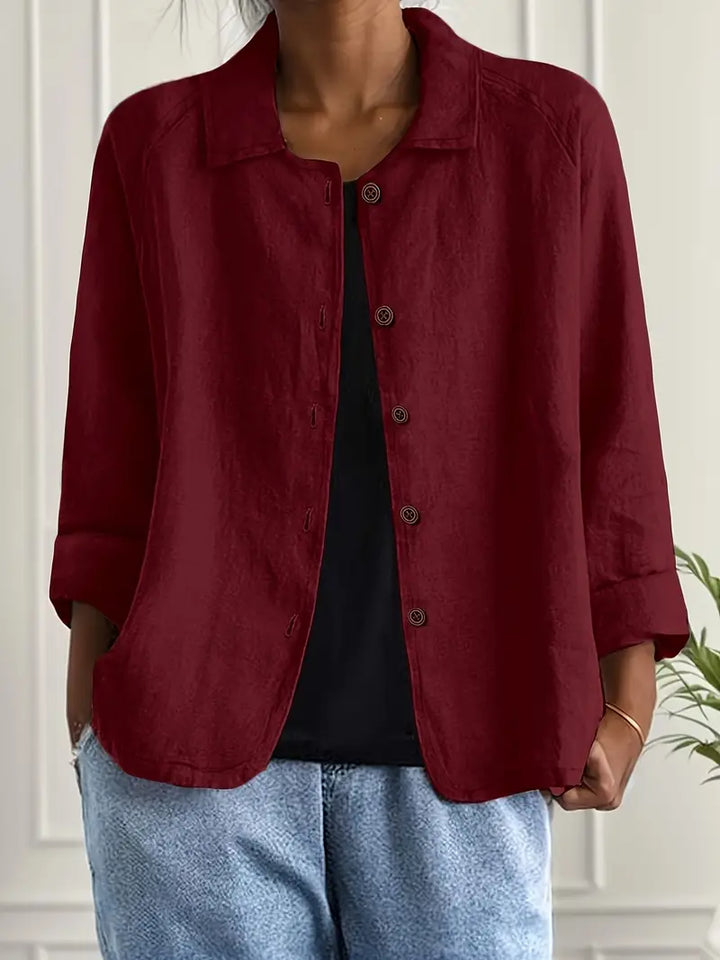 Side view of women's collared button-front casual top. Relaxed fit, three-quarter sleeves. Versatile spring look.