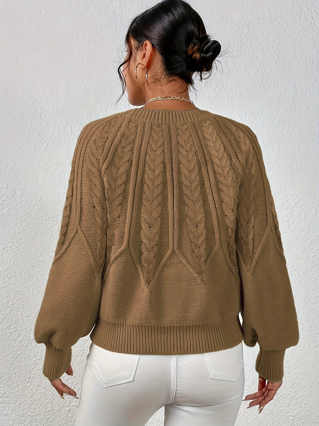 Cozy knit women's cable sweater, relaxed fit, fashionable lantern sleeves, perfect for chilly days.