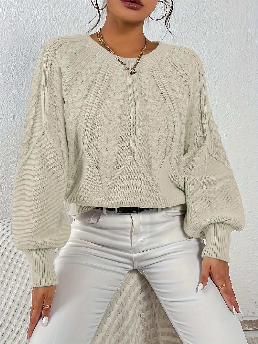 Warm women's cable knit pullover with a comfortable relaxed fit and elegant lantern sleeves.