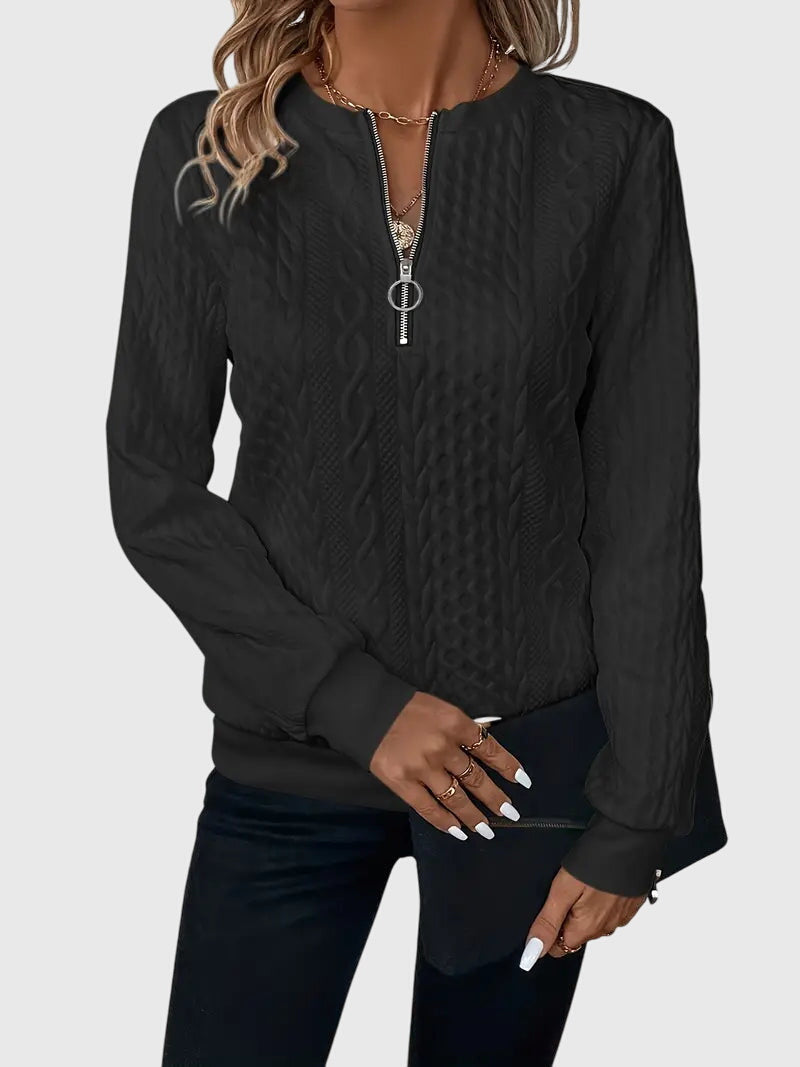 Quarter-zip women's pullover with intricate cable knit design.