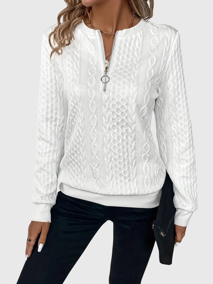 Close-up: Detailed cable pattern on women's quarter-zip sweater.