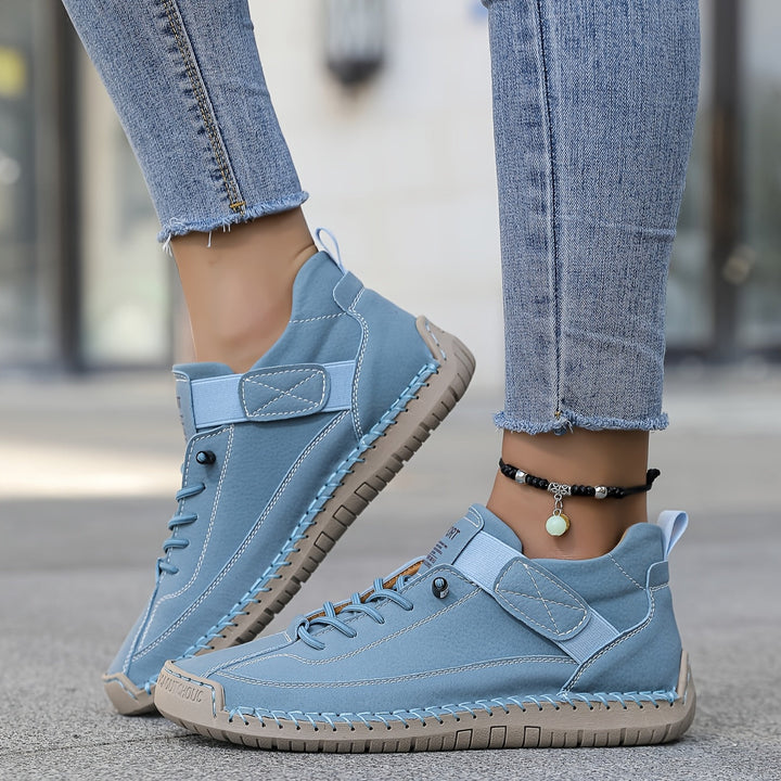 Comfortable women's casual sneakers, stitched detailing on low-top design, classic lace-up style footwear.