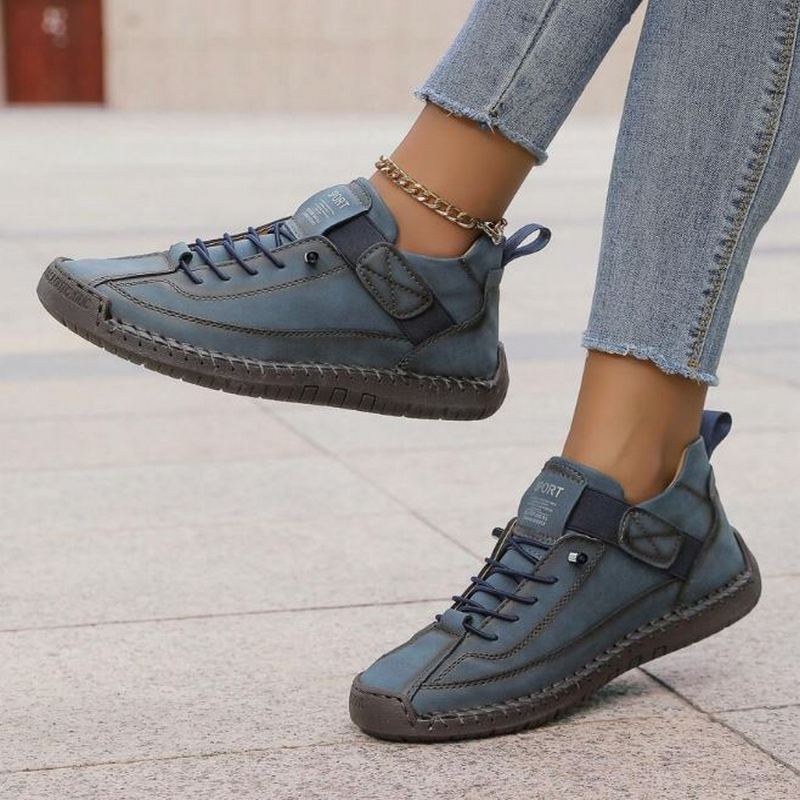 White women's casual sneakers with distinctive stitched panels, secure lace-up closure, and comfortable low-top design.