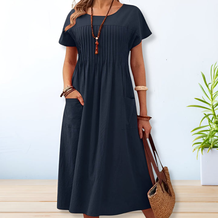 Women's relaxed fit pleated midi dress with pockets, a stylish and comfortable choice for casual outings.