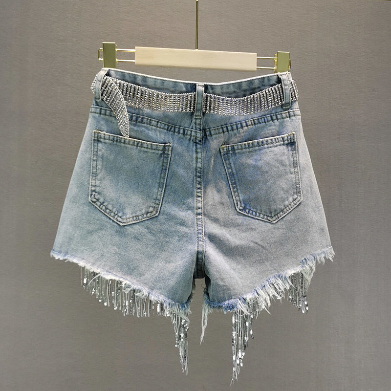 Stylish women's blue denim shorts with decorative tassels, great for casual summer wear.