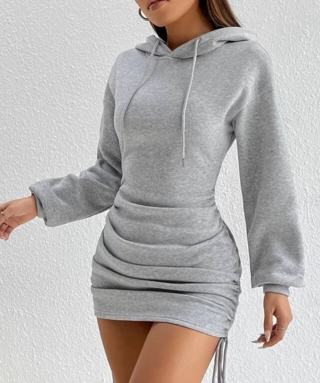 Soft women's long sleeve hoodie dress featuring adjustable side ruching for a custom fit. Chic.