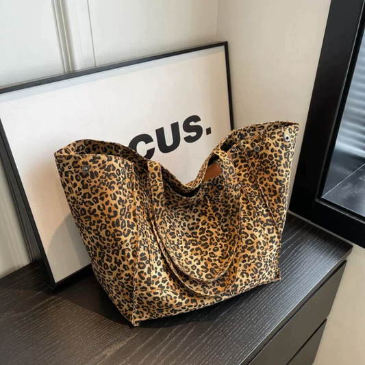 Women's chic leopard print handbag with spacious interior, perfect fashion accessory for any outfit.