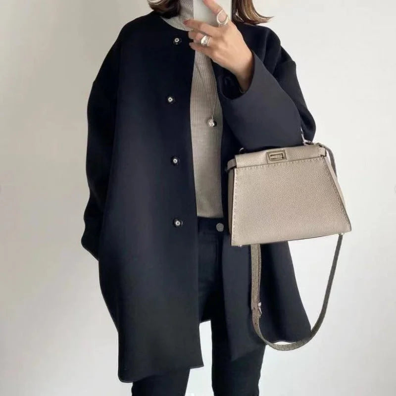 Elegant women's oversized button coat in a minimalist style, ideal for fall & winter fashion. Features large buttons.