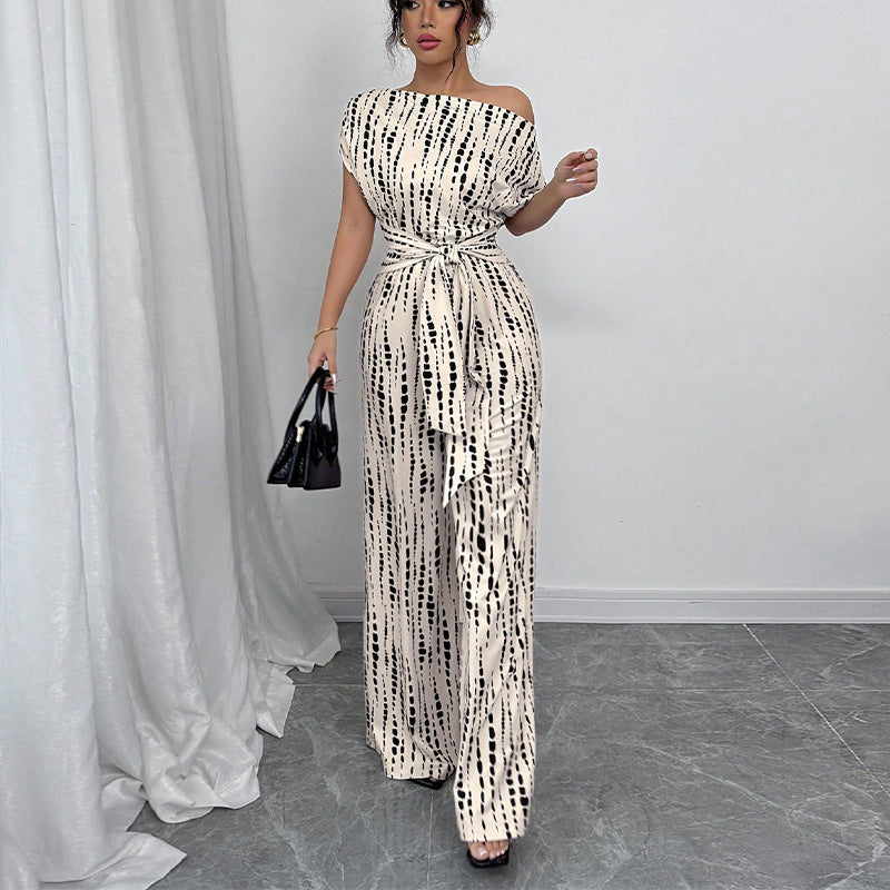 Elegant women's printed wide leg jumpsuit with a unique one-shoulder and belted silhouette for a modern, chic look.