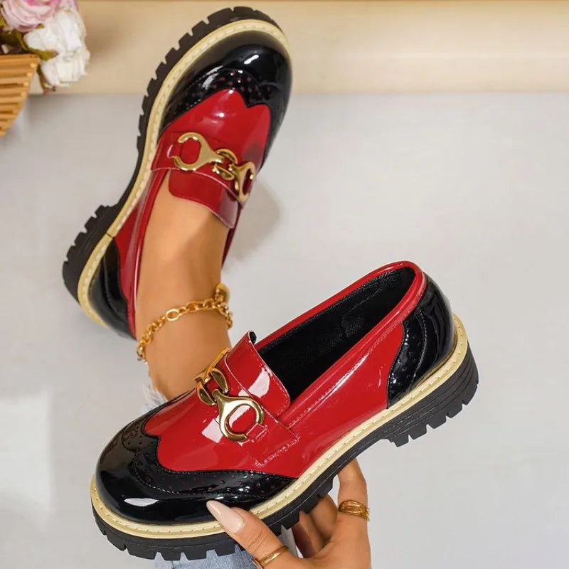 Side view of women's chic loafers with textured material and prominent gold horsebit detail.