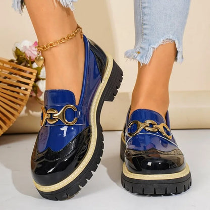 Pair of fashionable women's loafers with a glossy finish and elegant gold horsebit for a chic look.
