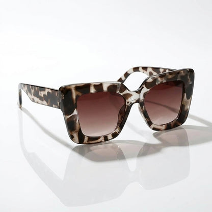 Woman wearing chic square sunglasses, showcasing the stylish fashion eyewear in a bright outdoor setting.