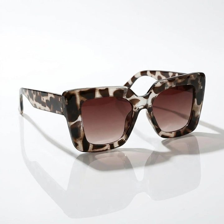Woman wearing chic square sunglasses, showcasing the stylish fashion eyewear in a bright outdoor setting.