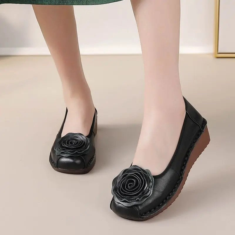 Top view of a pair of women's stylish comfort loafers with elegant floral appliqué, ready to wear.