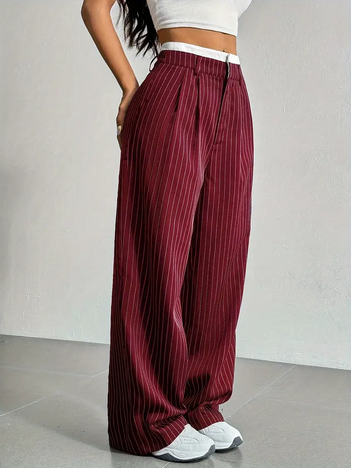 Detailed view of women's pinstripe wide-leg trousers, highlighting the fabric and relaxed, flowing design.