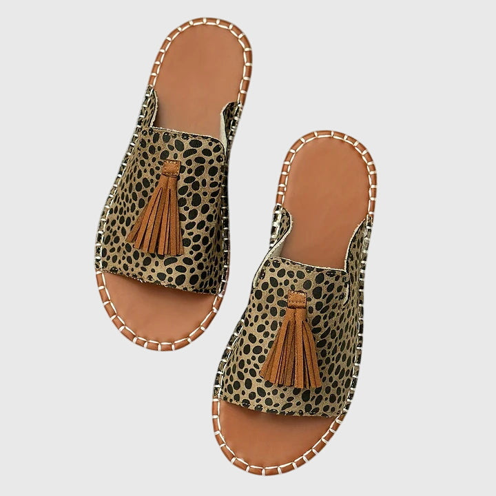 Stylish women's casual slip-on sandals with decorative tassel straps & comfortable flat sole.