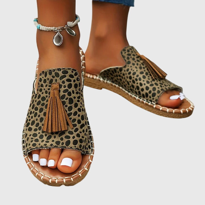 Vacation-ready women's slip-on sandals with comfortable flat sole & stylish tassel straps.