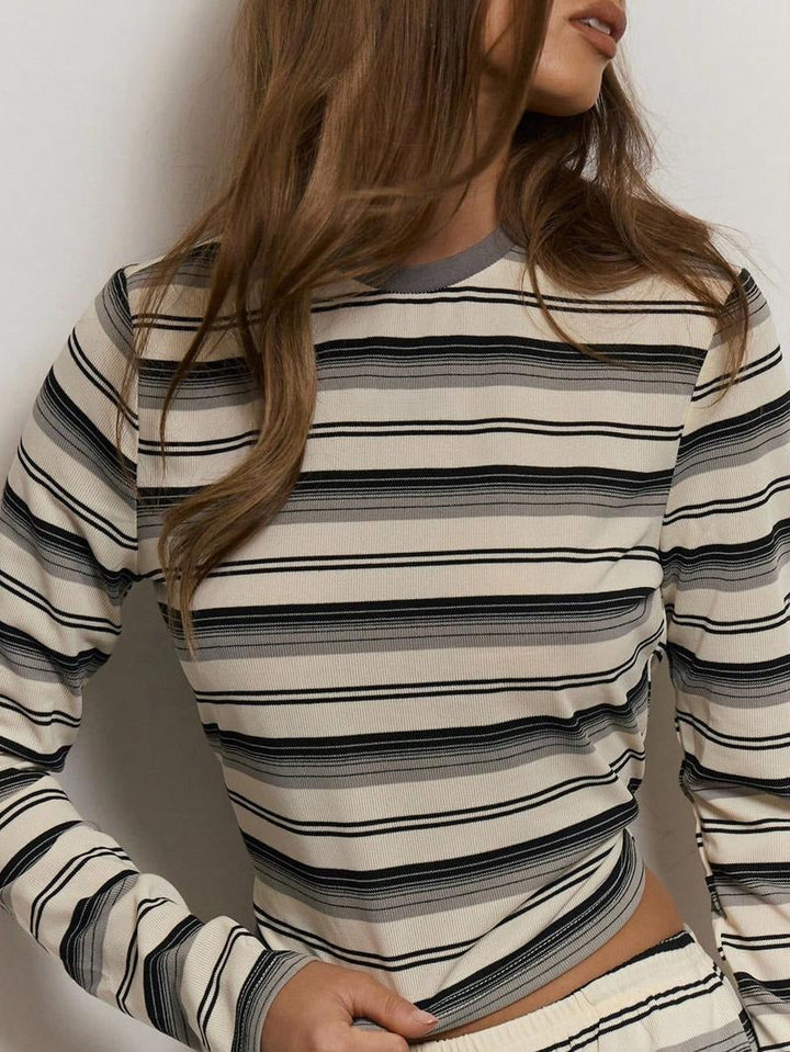 Woman models a fashionable striped knit two-piece lounge set, showcasing its comfortable and casual elegance.