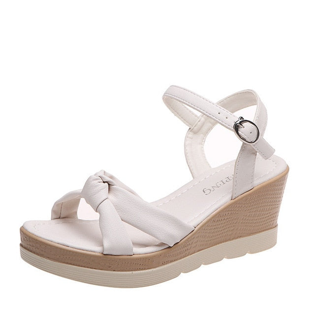 Comfortable women's white wedge sandals with platform sole and secure ankle strap, great for summer.