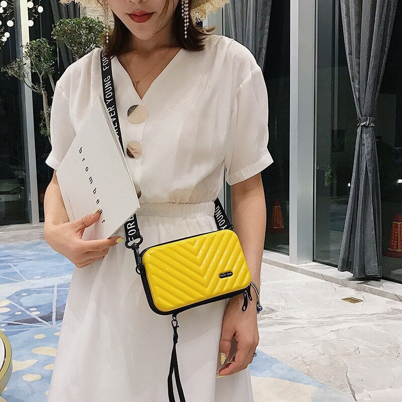 Women's compact hard shell crossbody bag, spacious for essentials. Practical travel mini handbag accessory.