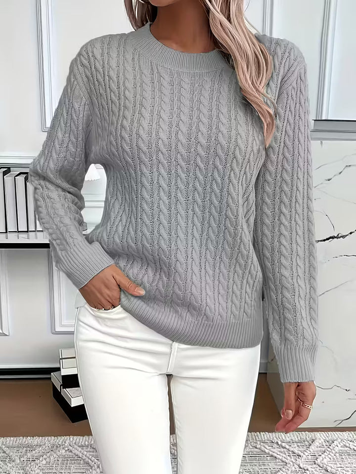 Front view of a women's cozy cable knit crew neck sweater, showcasing its soft texture & autumn fashion.