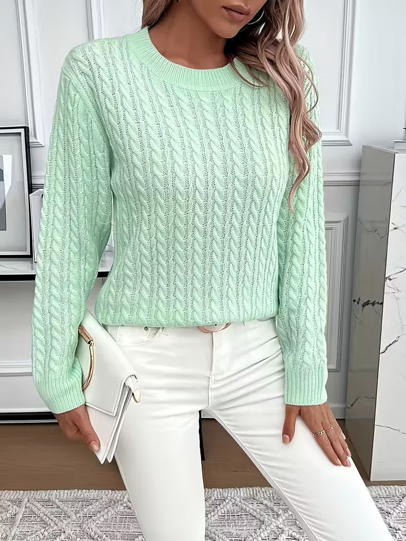 Woman wearing a comfortable long sleeve cable knit crew neck sweater, showcasing casual autumn style.