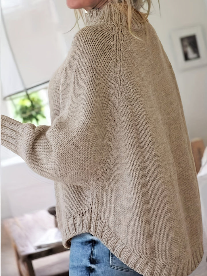Stylish women's high-neck cable knit sweater, featuring an oversized fit and elegant flared hem for comfort.
