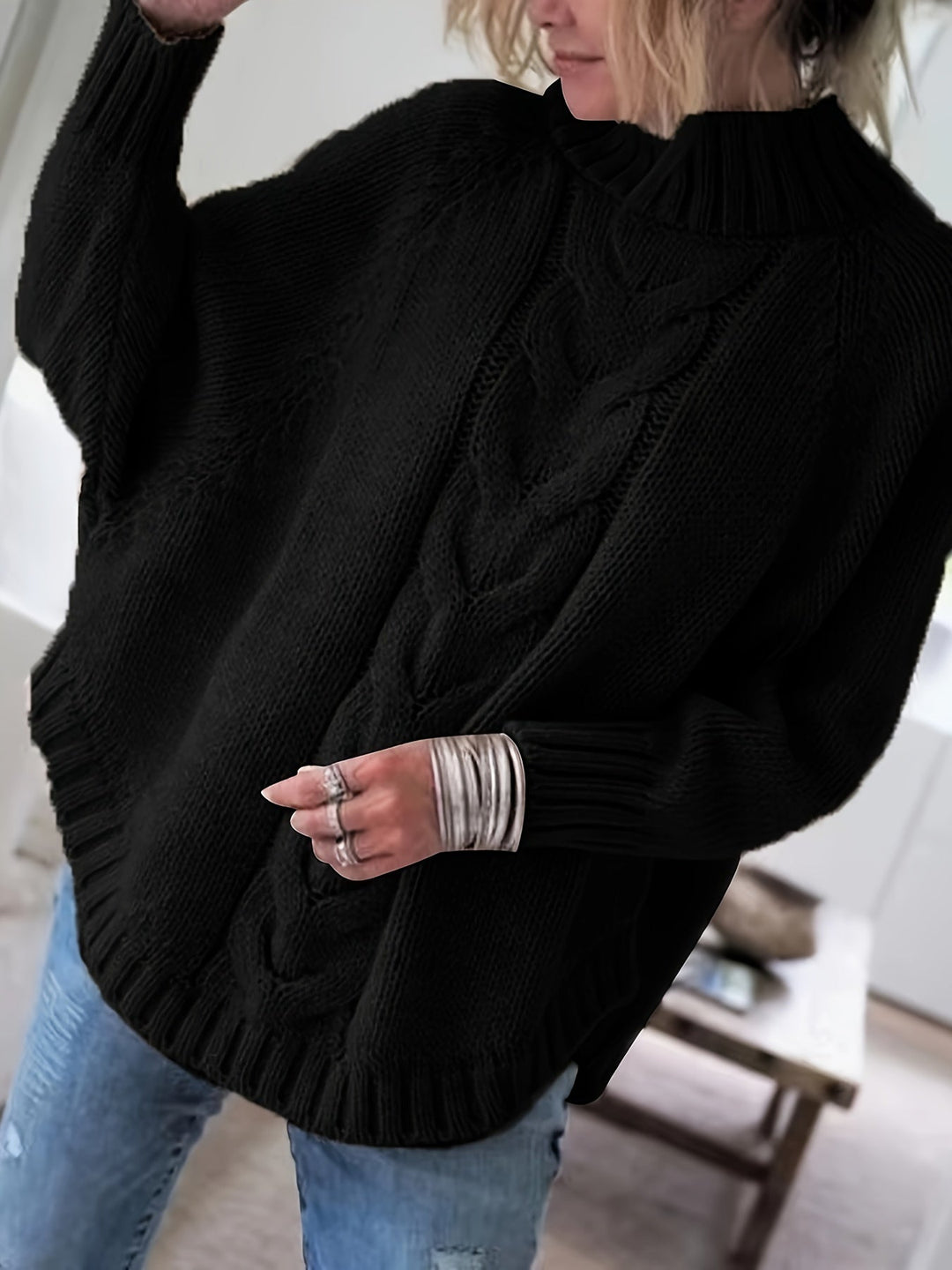 Chic oversized cable knit sweater for women, featuring a high neck & flared hem. Cozy fall/winter wear.