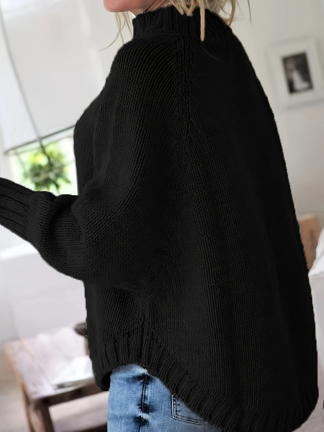 Warm winter wear: women's cozy cable knit high-neck sweater, oversized with a fashionable flared hem.
