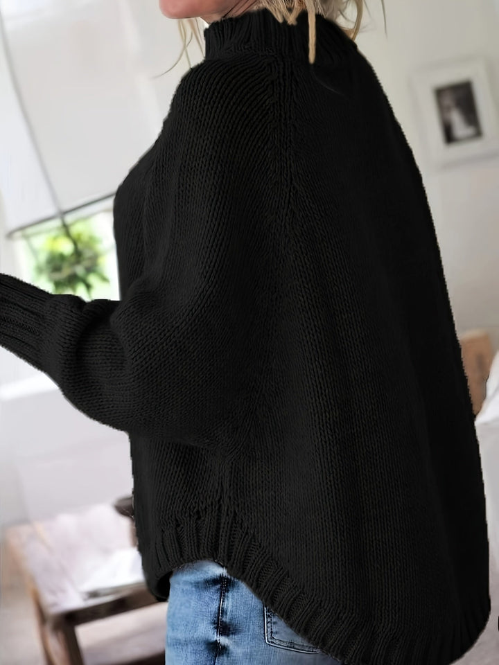 Warm winter wear: women's cozy cable knit high-neck sweater, oversized with a fashionable flared hem.
