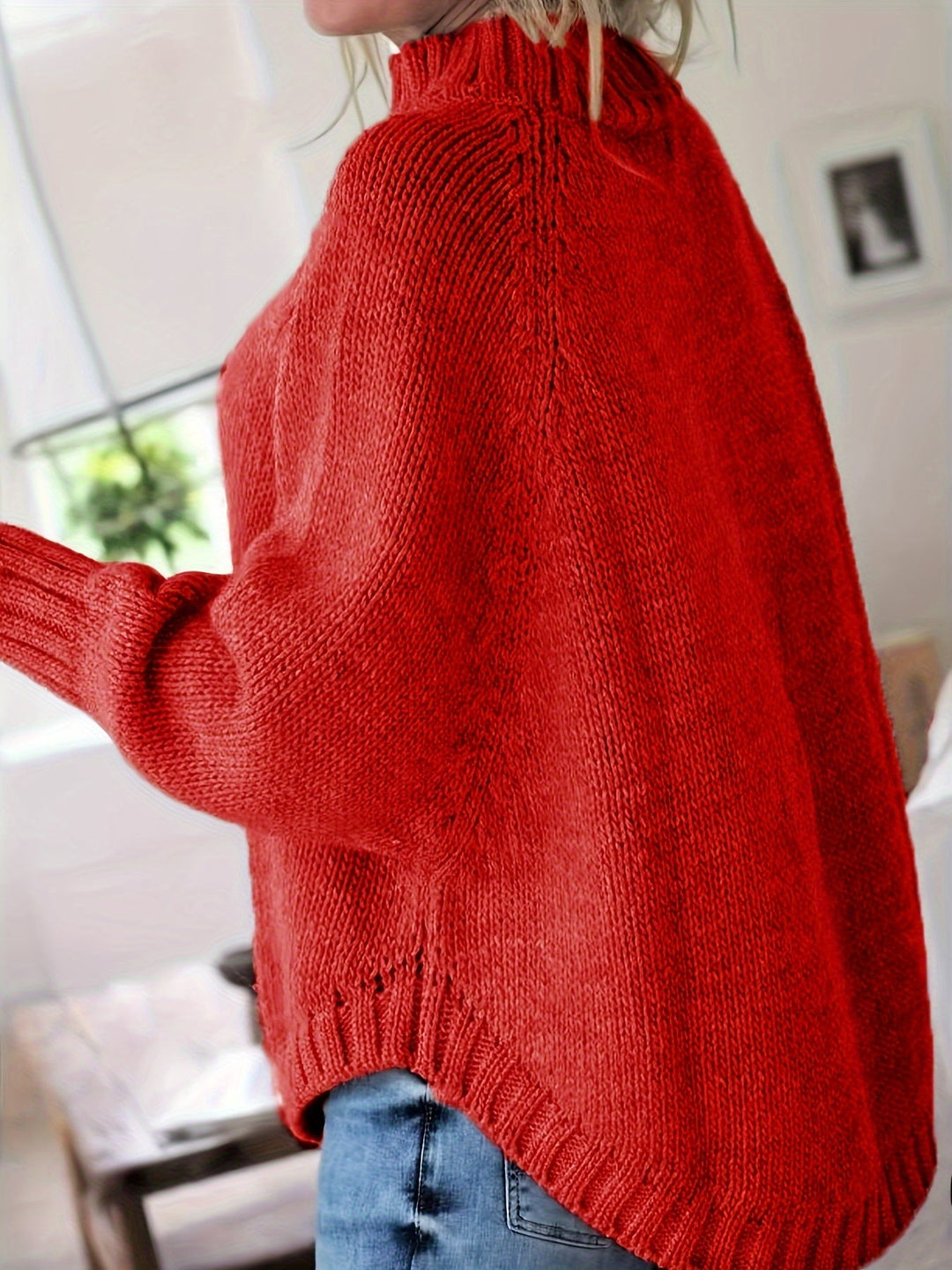 Elegant women's cable knit sweater. High-neck, flared hem, and batwing sleeves for a chic, cozy look.
