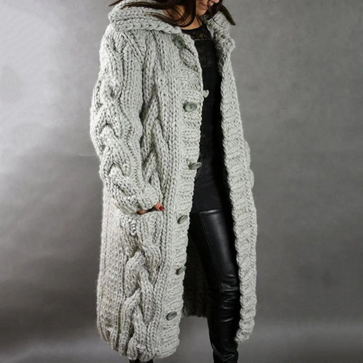 Stylish women's long hooded cable knit cardigan. Versatile maxi length, ideal for cozy layering outerwear.