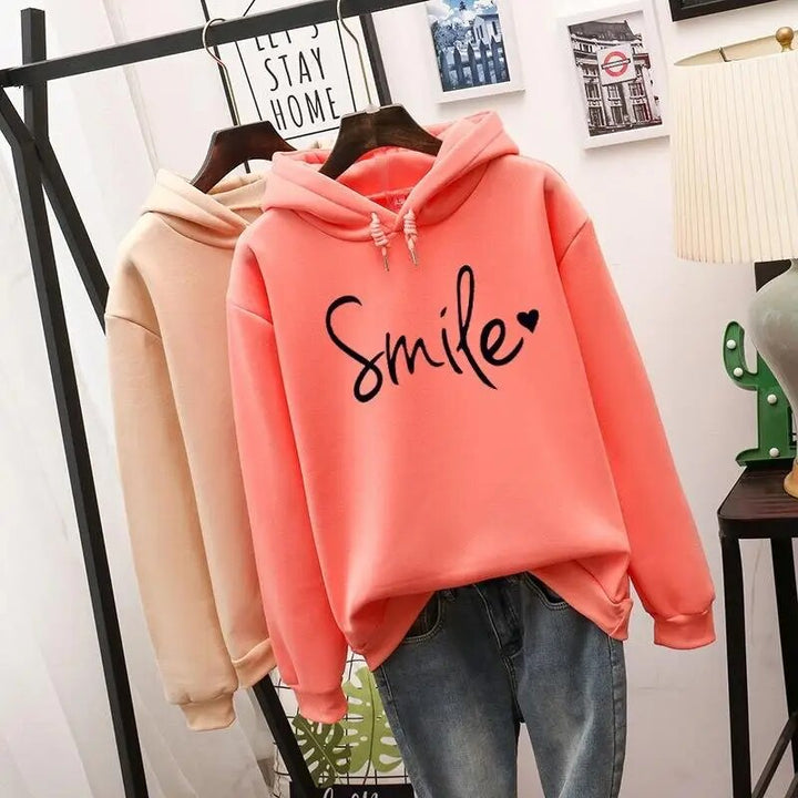 Fall/Winter women's long sleeve hoodie featuring a happy smile graphic. Comfortable & stylish for cozy days.